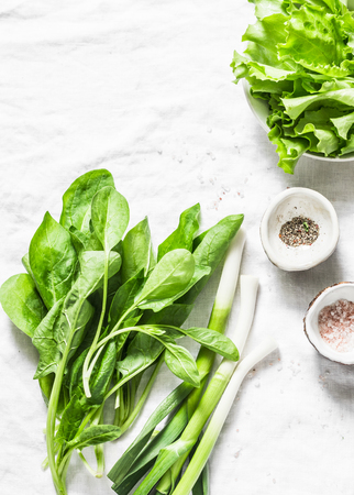 Fresh spinach, garlic, lettuce salad on white background, top view. Free space for textの写真素材