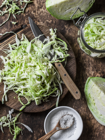 Cut cabbage on wooden chopping board on wooden background, top view. Vegetarian, slimming, diet food concept. Flat layの写真素材