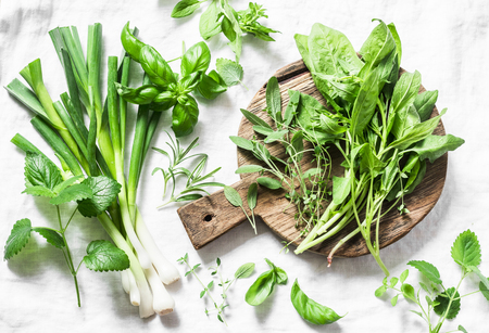 Garden herbs - spinach, basil, thyme, rosemary, sage, mint, onion, garlic on a light background, top view. Fresh food ingredients. Flat layの写真素材
