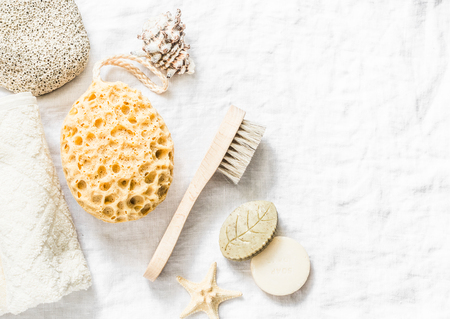 Shower accessories - face brush, sponge, pumice stone, towel, soap on a light background, top view. Cleansing of the skin health concept. Flat layの写真素材