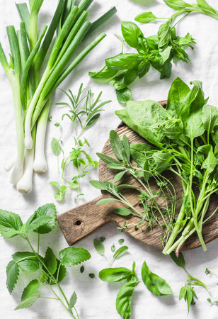 Garden herbs - spinach, basil, thyme, rosemary, sage, mint, onion, garlic on a light background, top view. Fresh food ingredients. Flat layの写真素材