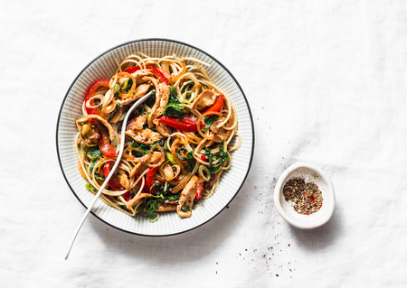 Teriyaki chicken, bell peppers, onions, spinach and rice noodles stir fry on white background, top view. Asian style healthy foodの写真素材