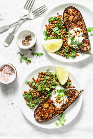 Harissa roasted eggplant with lentil and herb salad on a light background, top view.  Vegetarian food concept. Flat layの写真素材