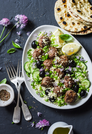 Greek lamb meatballs with avocado greek yogurt sauce, couscous and whole grain flatbread on a dark background, top view. Mediterranean style foodの写真素材