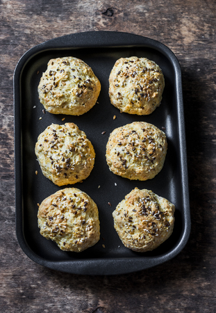 Homemade cheese buns on a baking tray on a wooden background, top viewの写真素材