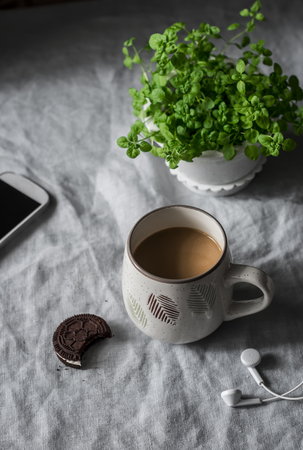 Cup of coffee, chocolate cookies, headphones on a cozy home tableの写真素材