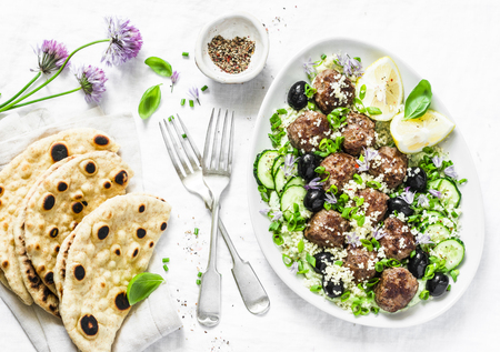 Greek lamb meatballs with avocado greek yogurt sauce, couscous and whole grain flatbread on a light background, top view. Mediterranean style foodの写真素材