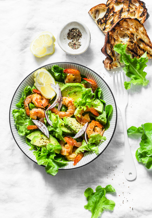 Orange marinated prawns, avocado, garden herbs salad - delicious healthy snack, appetizers, tapas on a light background, top view. Flat layの写真素材