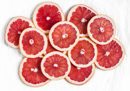 Fresh grapefruit slices on a light background, top view. Copy spaceの写真素材
