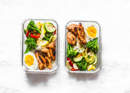Rice, stewed vegetables, egg, teriyaki chicken - healthy balanced lunch box on a light background, top view. Home food for office concept. Copy spaceの写真素材