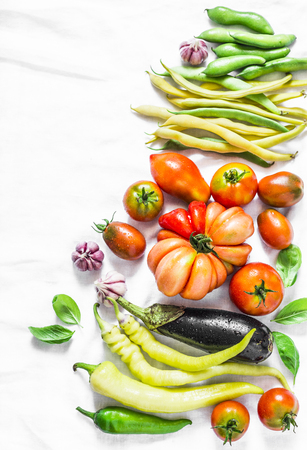 Vegetables background. Tomatoes, green beans, pepper, eggplant, garlic on a light background, top view. Flat lay, copy spaceの写真素材