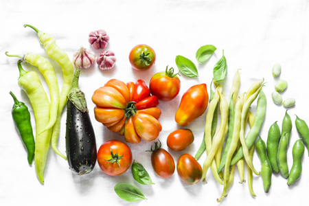 Vegetables background. Tomatoes, green beans, pepper, eggplant, garlic on a light background, top view. Flat lay, copy spaceの写真素材