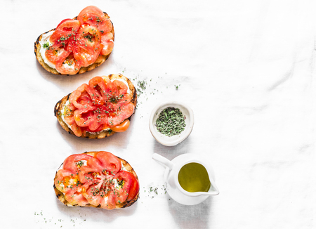 Tomatoes, cream cheese, oregano bruschetta on a light background, top view. Delicious appetizers, tapas, snack. Copy spaceの写真素材