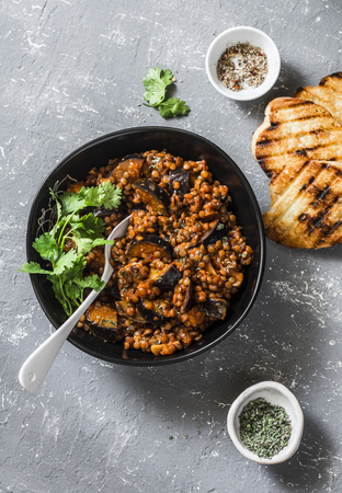 Lentils eggplant stewed in tomato sauce on gray background, top view. Healthy seasonal vegetarian lunchの写真素材