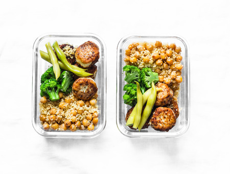 Healthy lunch box - spicy couscous with chickpeas, broccoli, green beans and turkey meatballs on dark background, top view. Copy spaceの写真素材