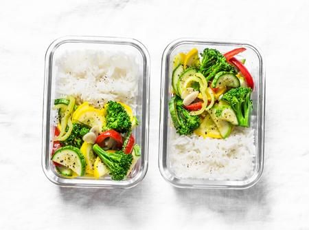 Vegetarian lunch box - stewed vegetables and rice on a light background, top view. Health food conceptの写真素材
