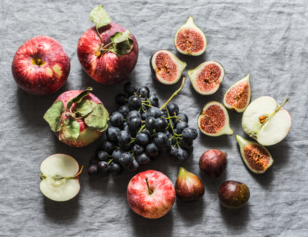 Seasonal autumn fruits - apples, grapes, figs on a gray background, top view. Flat layの写真素材