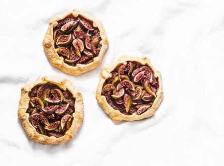 Caramelized figs tarts or pies on a light background, top view. Flat layの写真素材