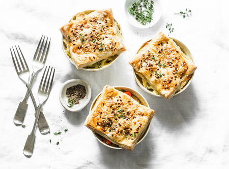 Chicken and seasonal vegetables portion pot pie on a light background, top view. Flat layの写真素材