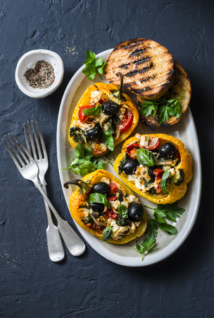 Baked bell peppers stuffed greek salad - delicious appetizers, snacks on a dark background, top viewの写真素材