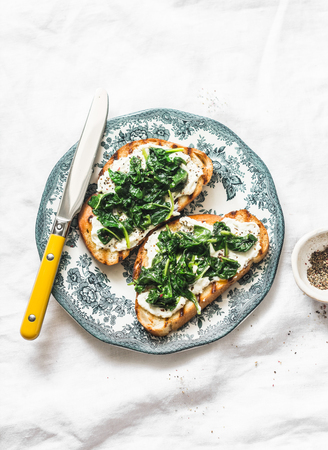 Fried spinach and labne sandwiches - delicious healthy breakfast or snack on a light background, top viewの写真素材