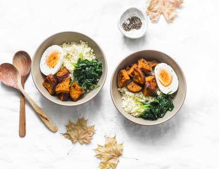 Sweet potato, couscous, spinach, egg buddha bowl on light background, top view. Vegetarian food conceptの写真素材