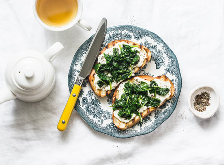 Fried spinach and labne sandwiches - delicious healthy breakfast or snack on a light background, top viewの写真素材