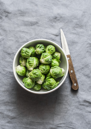 Fresh brussels sprouts in white bowl on grey background, top viewの写真素材