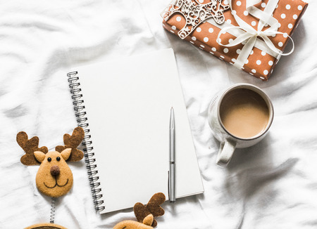 Christmas background. Clean blank notepad, coffee, gift box, christmas decorations on light background, top view. Flat lay, cope spaceの写真素材