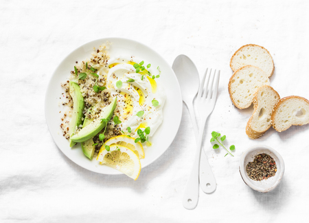 Fresh labne with quinoa and avocado - delicious healthy breakfast or snack on light background, top viewの写真素材