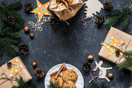 Christmas background with homemade gifts, christmas decorations, cookies and free space, top view. Flat lay, dark backgroundの写真素材