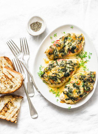 Baked chicken breast with tomatoes, spinach and mozzarella - delicious diet lunch in mediterranean style on a light background, top viewの写真素材