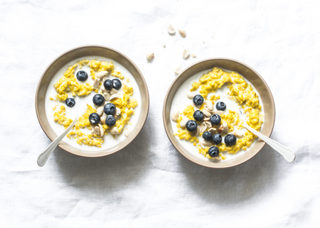 Coconut milk turmeric oatmeal porridge on a light background, top view. Gluten free, vegetarian food conceptの写真素材