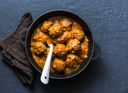 Meatballs in tomato sauce in cast iron pan on dark background, top viewの写真素材