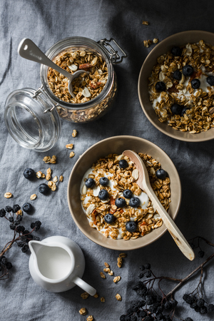 Homemade peanut butter granola with greek yogurt and blueberries on a grey background, top view. Healthy energy breakfast or snack. Flat layの写真素材