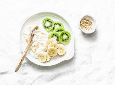 Healthy diet breakfast - greek yogurt with honey and fruit on a light background, top view. Copy spaceの写真素材