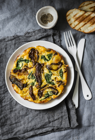 Porcini mushrooms, potatoes, spinach baked frittata - delicious breakfast, snack, tapas on a gray background, top viewの写真素材