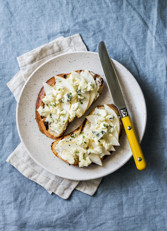 Pear, blue cheese, thyme sandwiches - delicious breakfast, snack, brunch on a blue background, top viewの写真素材