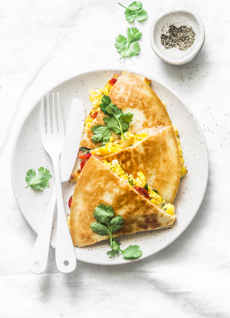 Scramble eggs vegetables ham quesadilla on a light background, top view. Tasty snack, tapas, breakfastの写真素材