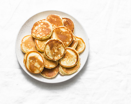 Heap of mini pancakes on a light background, top view. Delicious breakfast, brunch, dessert. Baby foodの写真素材