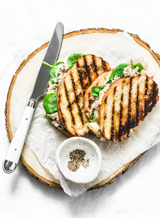 Canned tuna, mozzarella cheese, spinach hot sandwiches on a light background, top view. Delicious breakfast, brunch, tapas, snackの写真素材