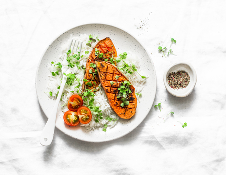 Grilled sweet potatoes with crunchy rice and micro greens on light background, top view. Vegetarian healthy food conceptの写真素材