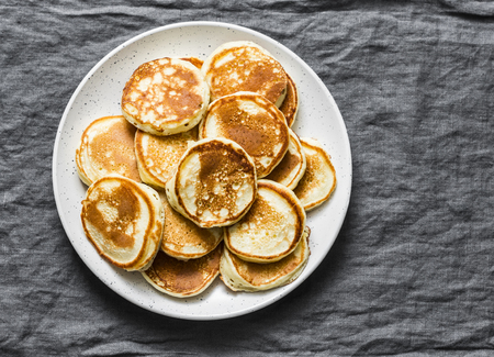 Heap of mini pancakes on a gray background, top view. Delicious breakfast, brunch, dessertの写真素材