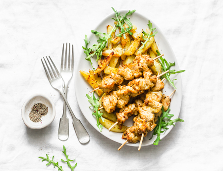 Greek chicken soulvaki with fried potatoes on a light background, top view. Chicken skewersの写真素材