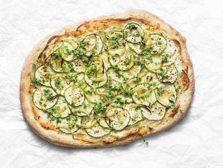 Vegetarian zucchini micro greens and vegetarian cheese flatbread on light background, top viewの写真素材