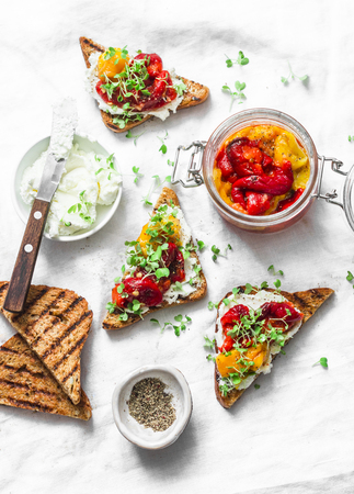 Whole grain sandwiches with marinated pickled roasted grilled sweet pepper, and cream cheese - delicious snack, appetizers, tapas on a light background, top viewの写真素材
