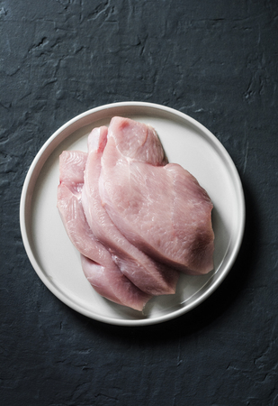 Raw turkey fillet chops on dark background, top view. Food ingredientsの写真素材