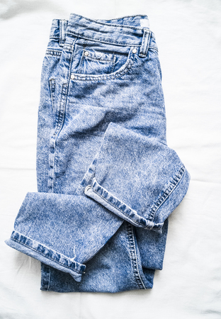 Blue faded mom jeans on a light background, top view. Fashion clothing conceptの写真素材