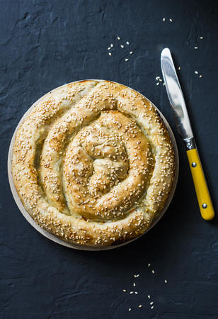 Greek spinach fresh ricotta puff pastry pie on a dark background, top view. Spanakopita pieの写真素材