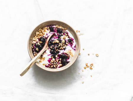 Greek yogurt with granola and blueberry sauce on light background top viewの写真素材